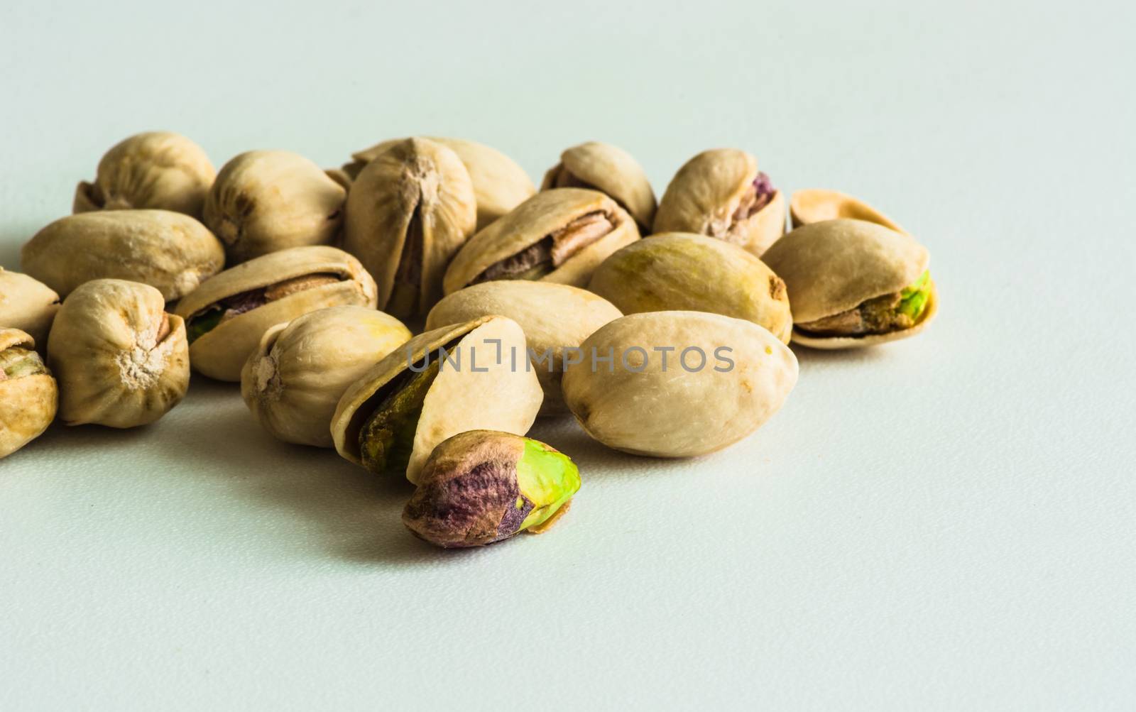 a group of pistachios, one is without its shell