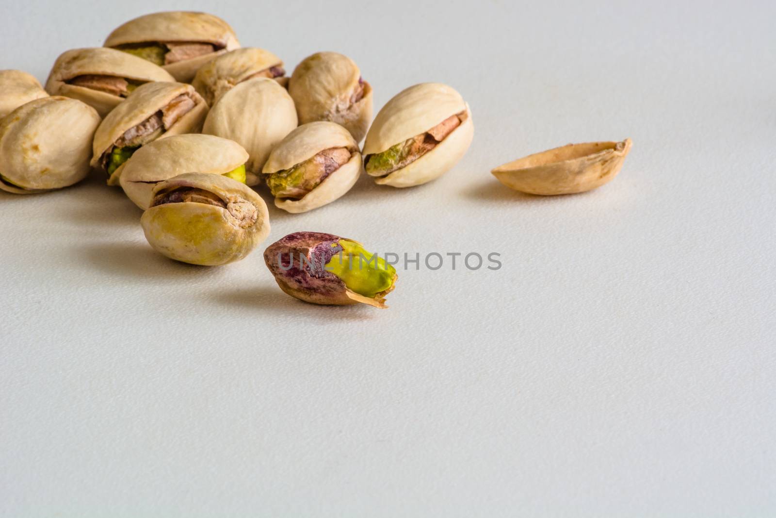 a group of pistachios, one is without its shell