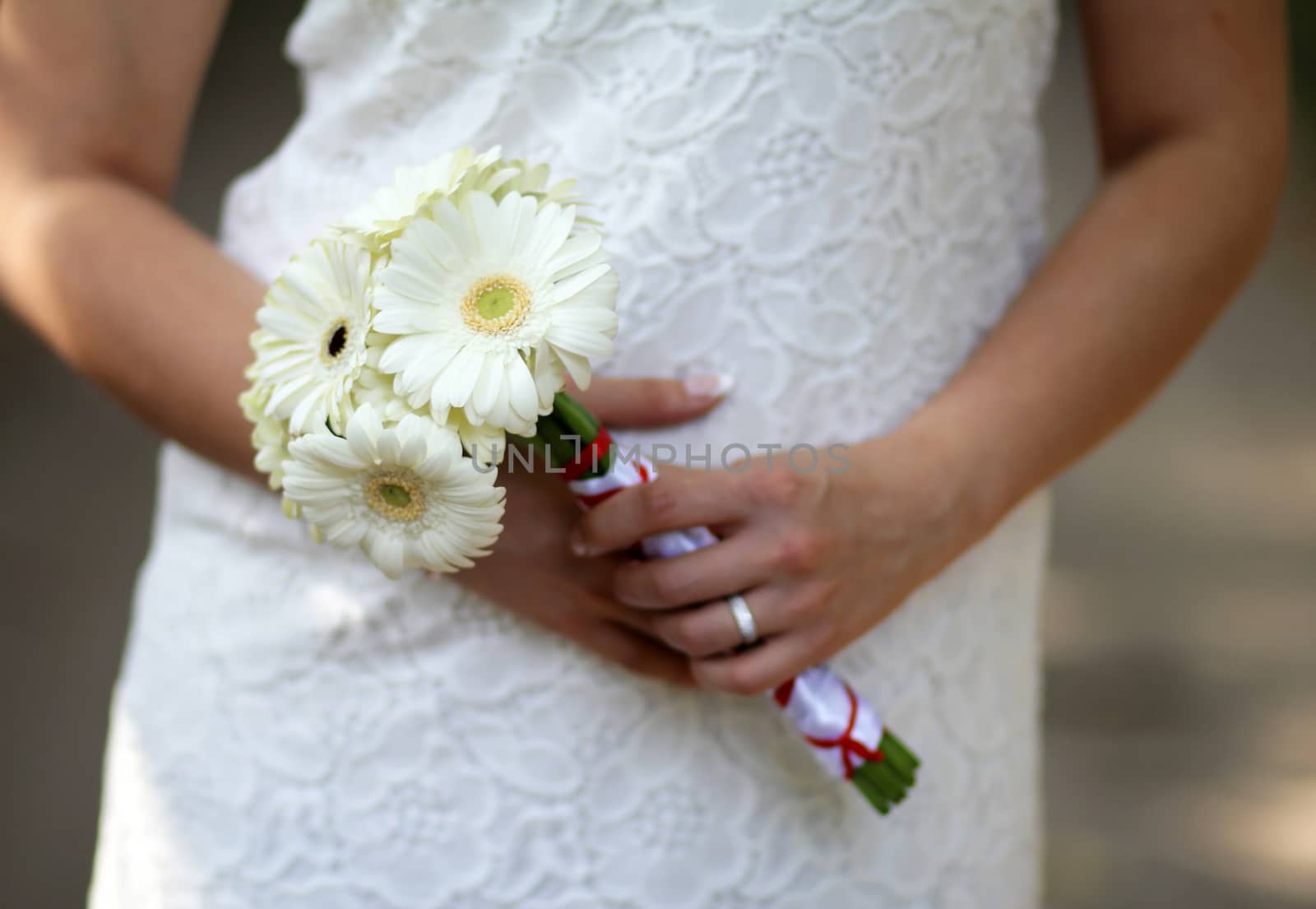 Wedding decorative bouquet of flowers with white opestkami in the hands of the bride