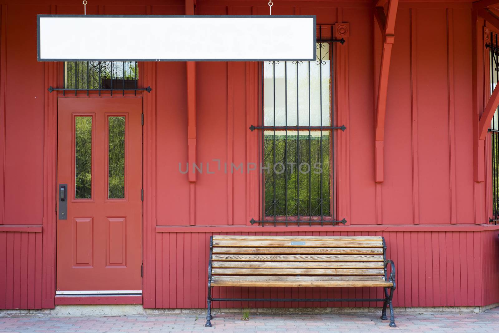 Empty bench by blank sign against red wooden walls