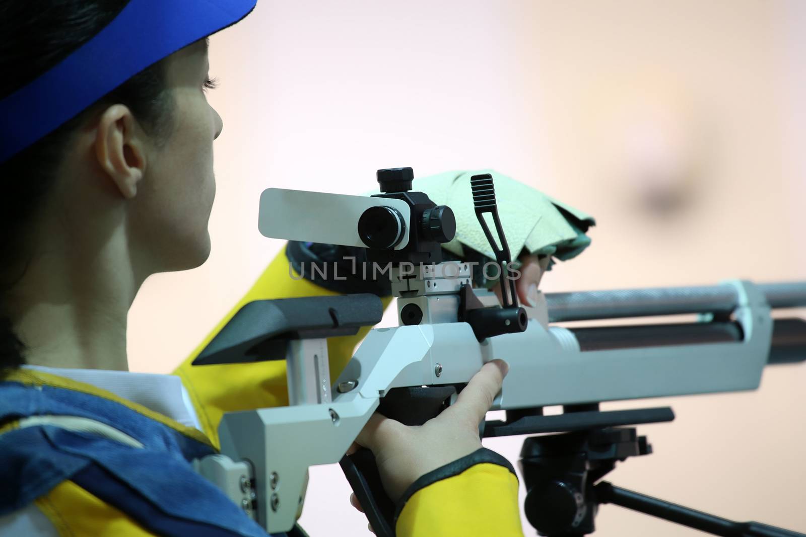 beautiful young woman aiming a pneumatic air rifle