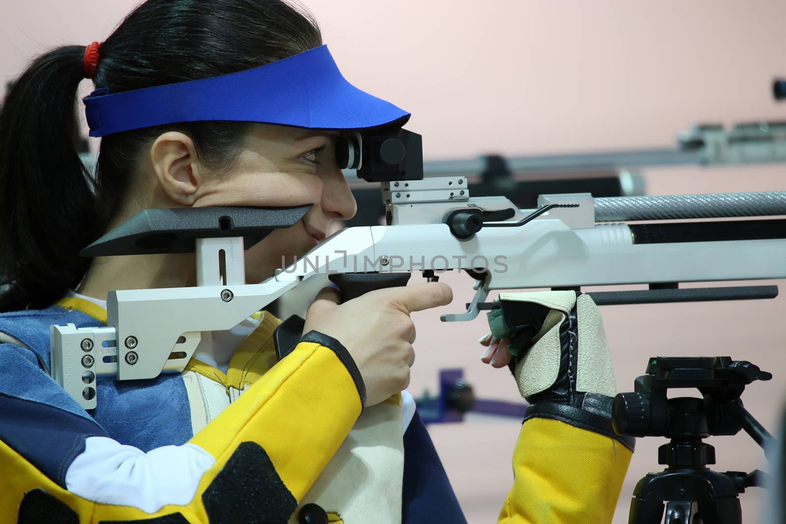 beautiful young woman aiming a pneumatic air rifle