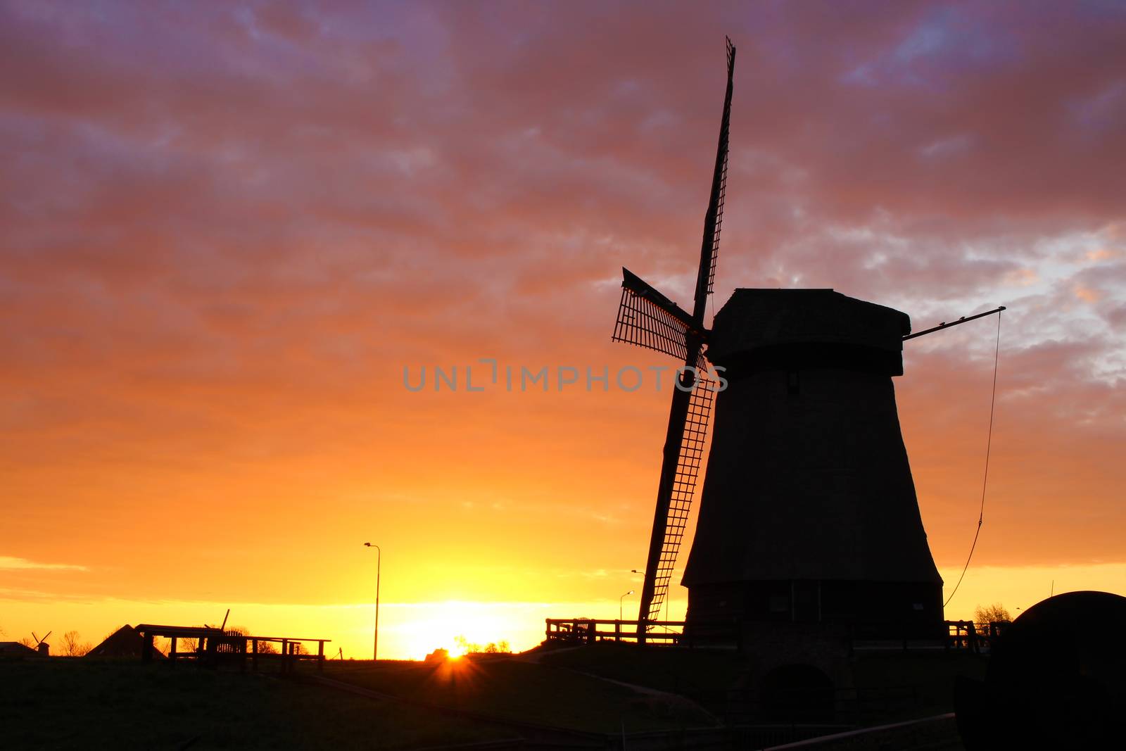 Silhouette of traditional windmill in Netherlands during sunrise