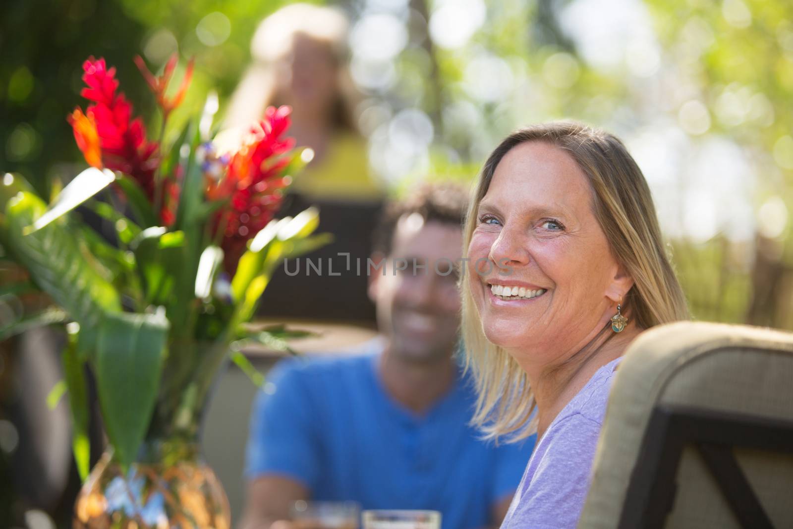 Smiling Woman at Table on Vacation by Creatista