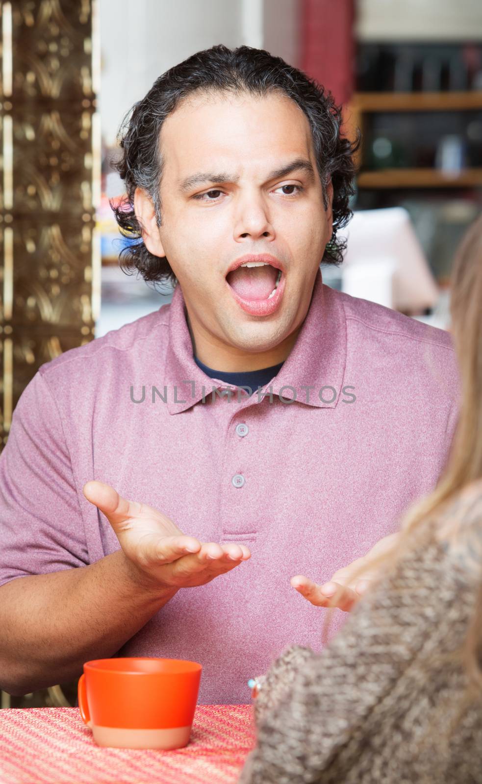 Frustrated man with woman at coffee house indoors