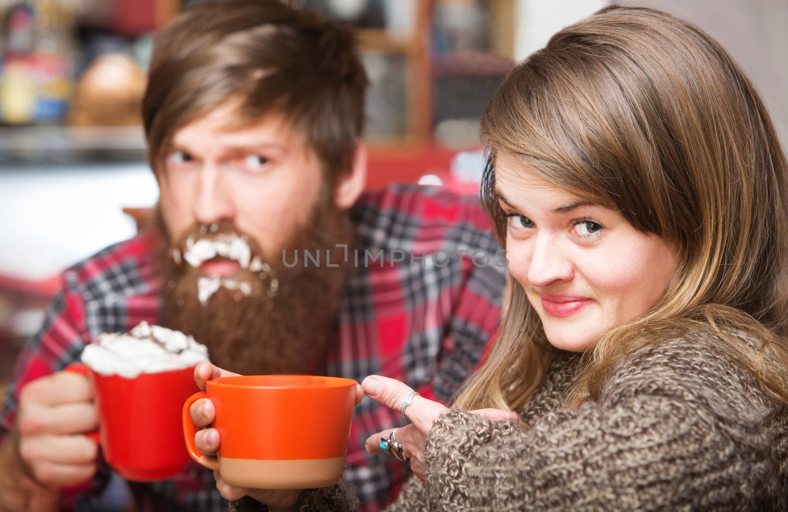 Grinning woman pointing to clueless man with cream on his beard