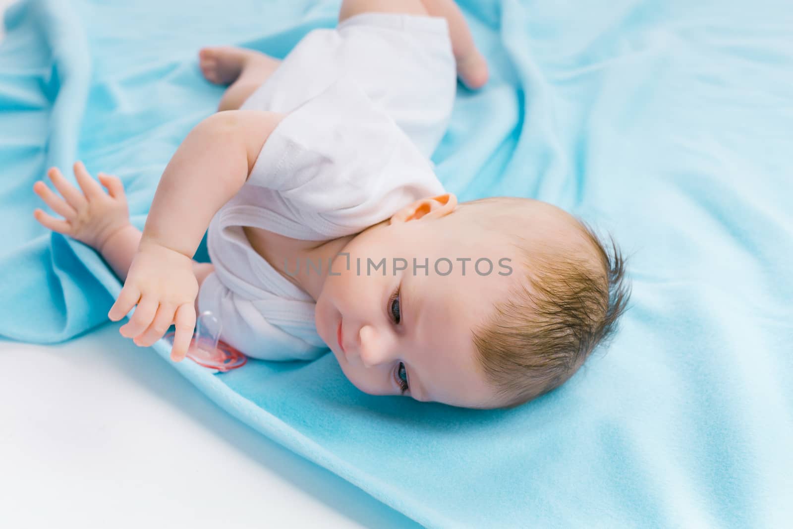 baby lying on a blue blanket by pzRomashka