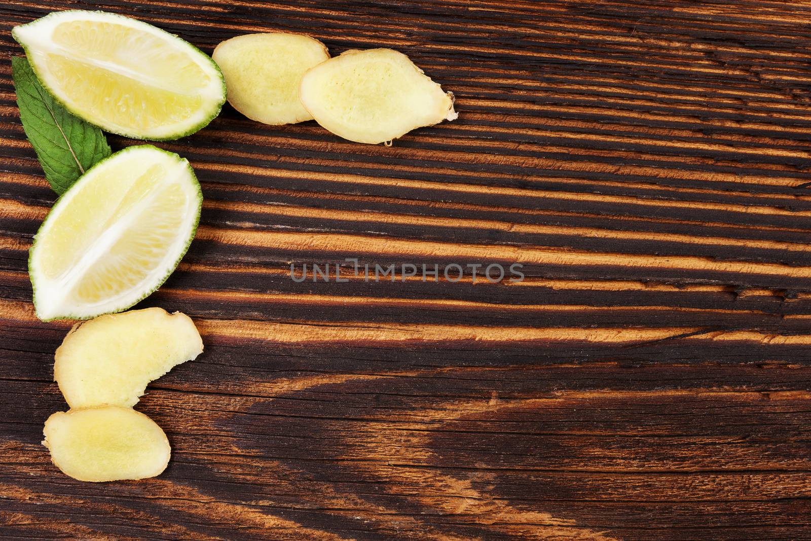 Healthy fruit eating. Ginger and lime on wooden table, top view with copyspace. Healthy fresh fruit eating. 
