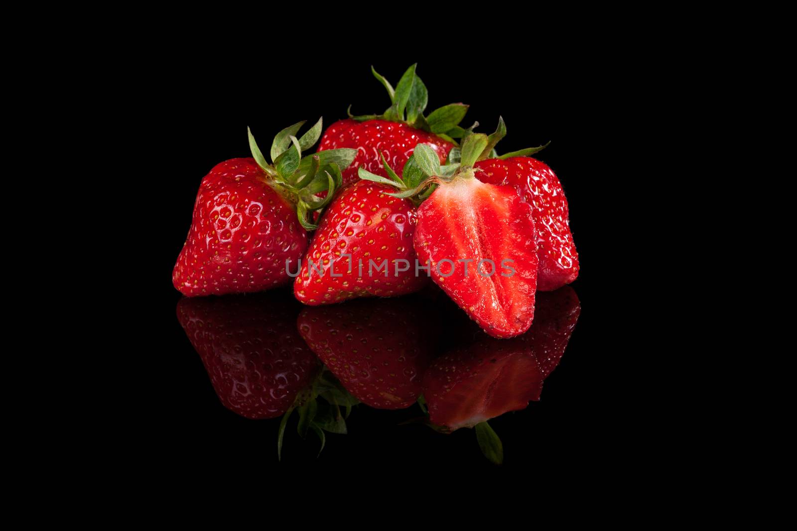 Delicious strawberries isolated on black background. Healthy summer fruit eating, minimal sparse style.