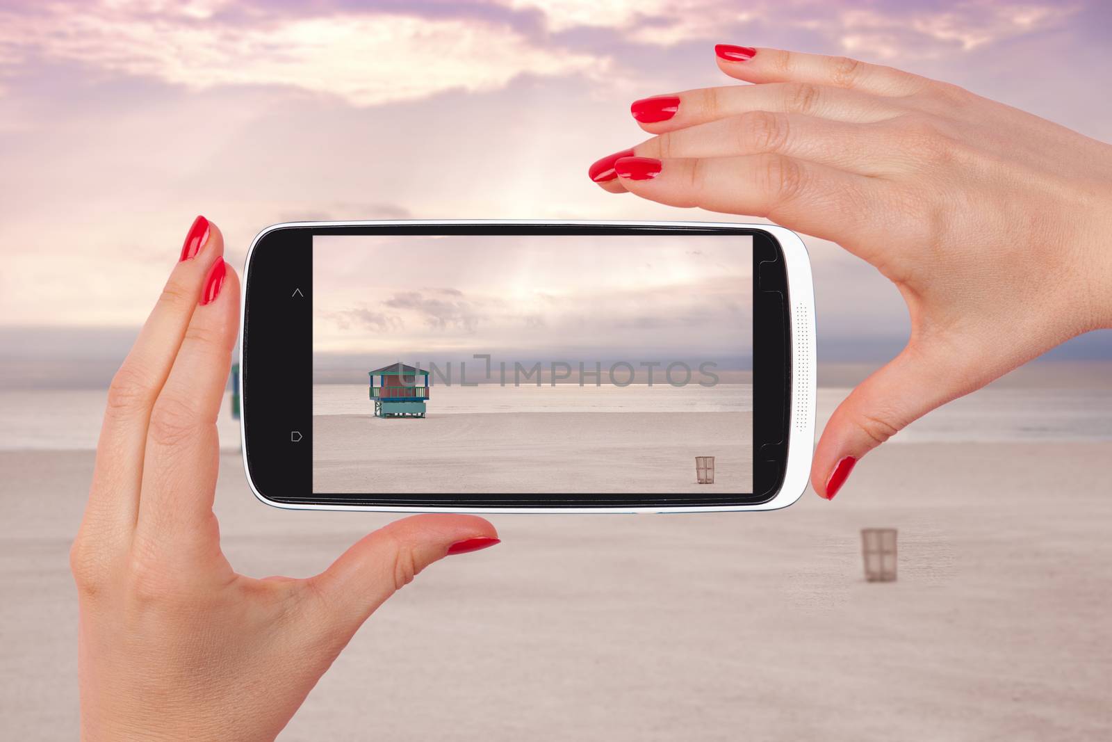 Female tourist taking snapshot with smartphone of lifeguard cabin, Miami Beach, Florida, USA. Backpacking, vagabonding, travelling.