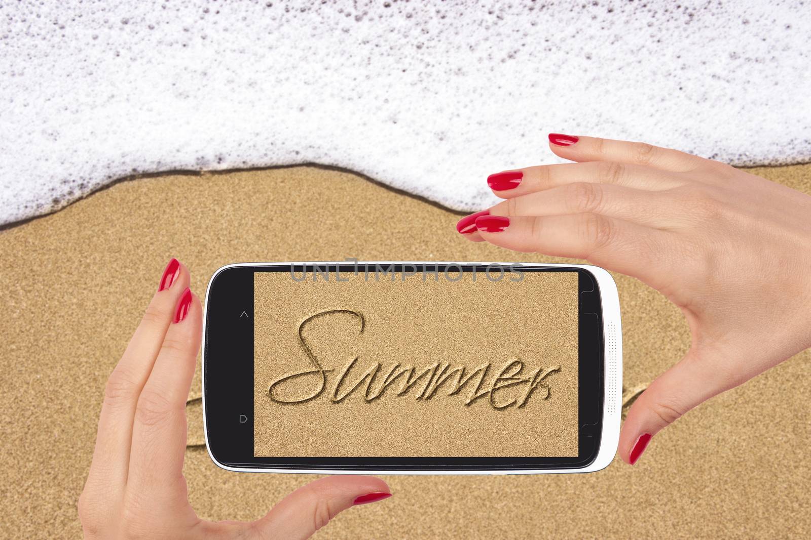 Beach snapshot. Sand beach with summer written in sand on smartphone screen in female hand. Female travelling.