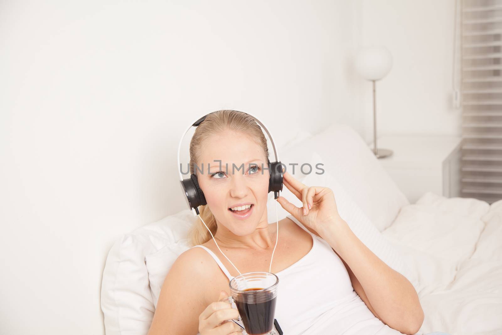 Pretty woman listening to music and drinking coffe by ifilms