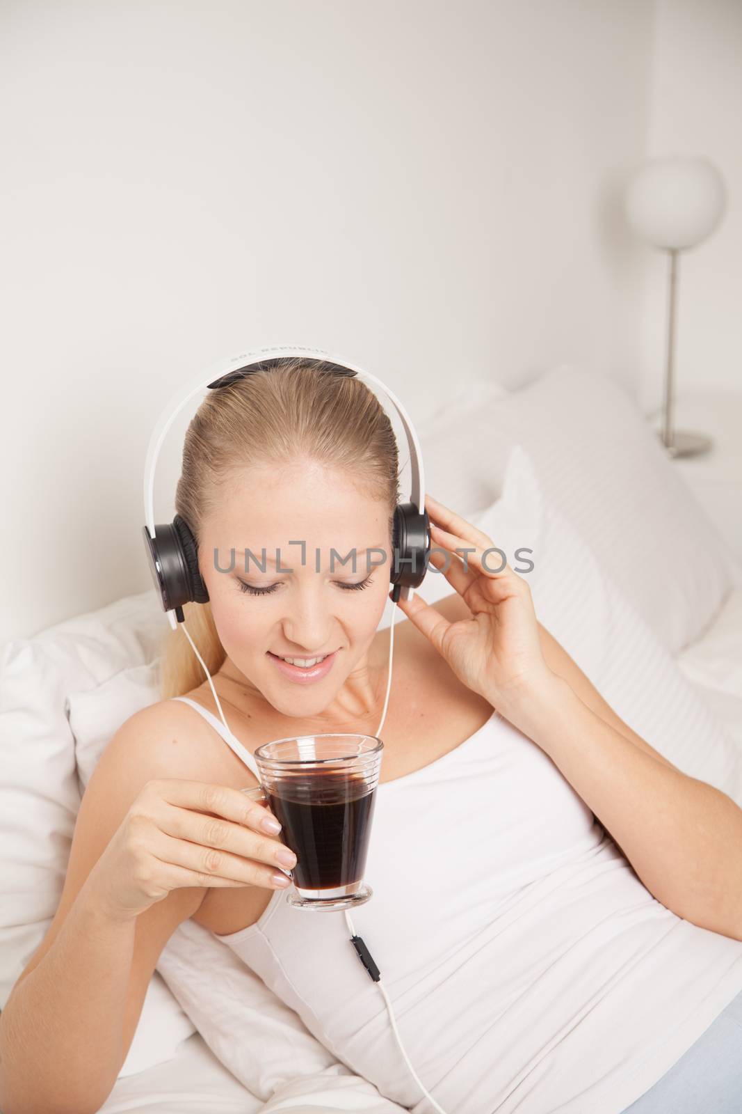 Young woman listening to music and drinking coffe by ifilms