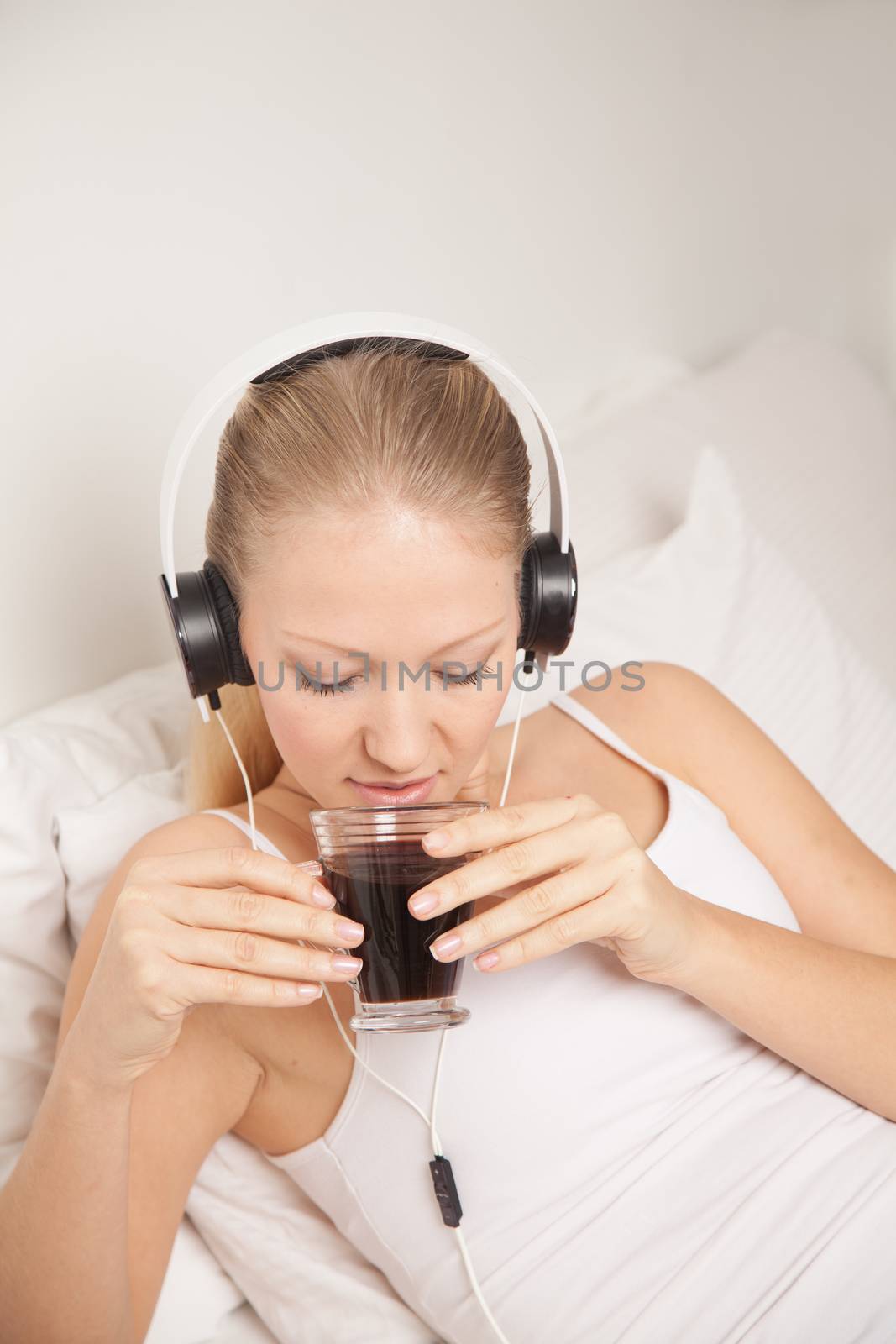 Young woman listening to music and drinking coffe