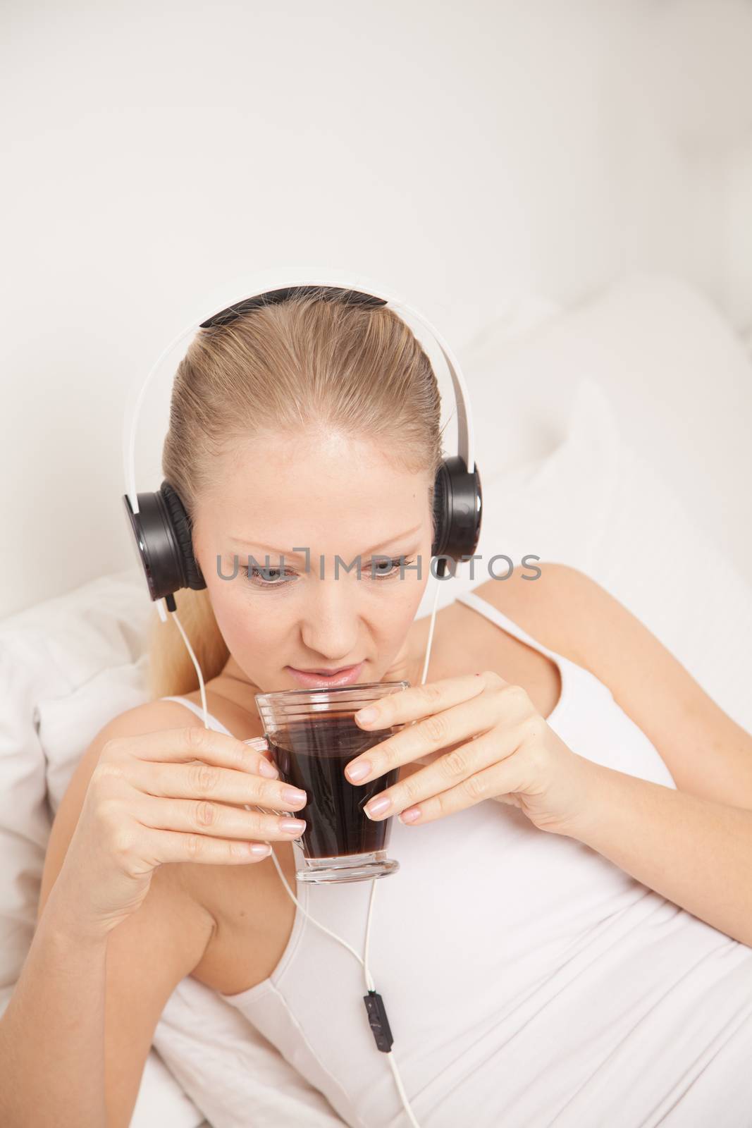 Pretty woman listening to music and drinking coffe by ifilms