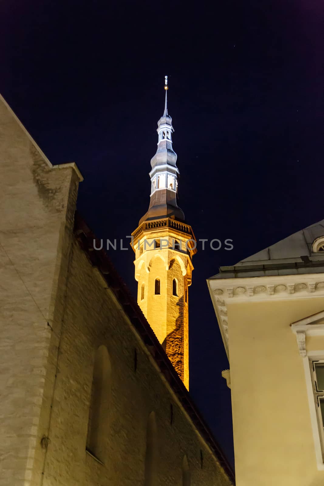 Front view of medieval Lutheran Church of the Holy Ghost in Tallinn, Estonia, in dark on navy blue sky background.