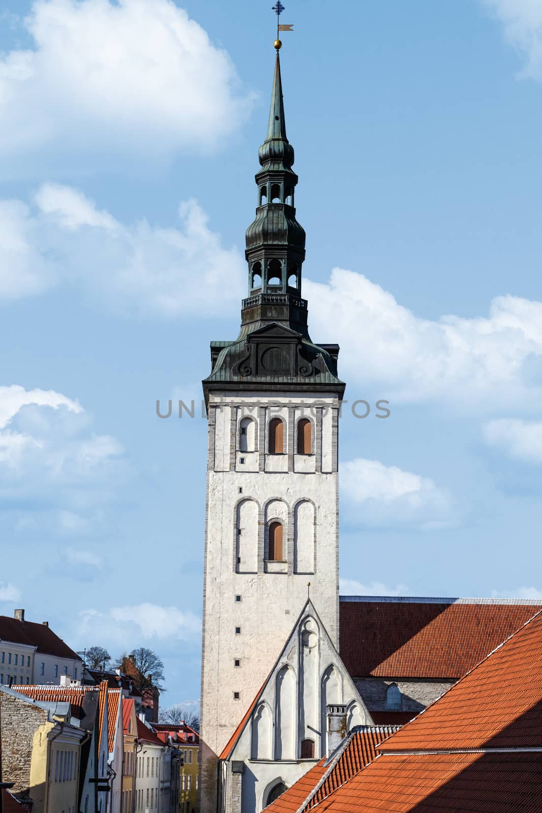 Front view of the medieval former St Nicholas Church, in Tallinn, Estonia, dedicated to Saint Nicholas, on blue cloudy sky background.