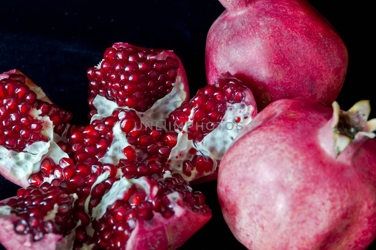Photo of open pomegranate on black background