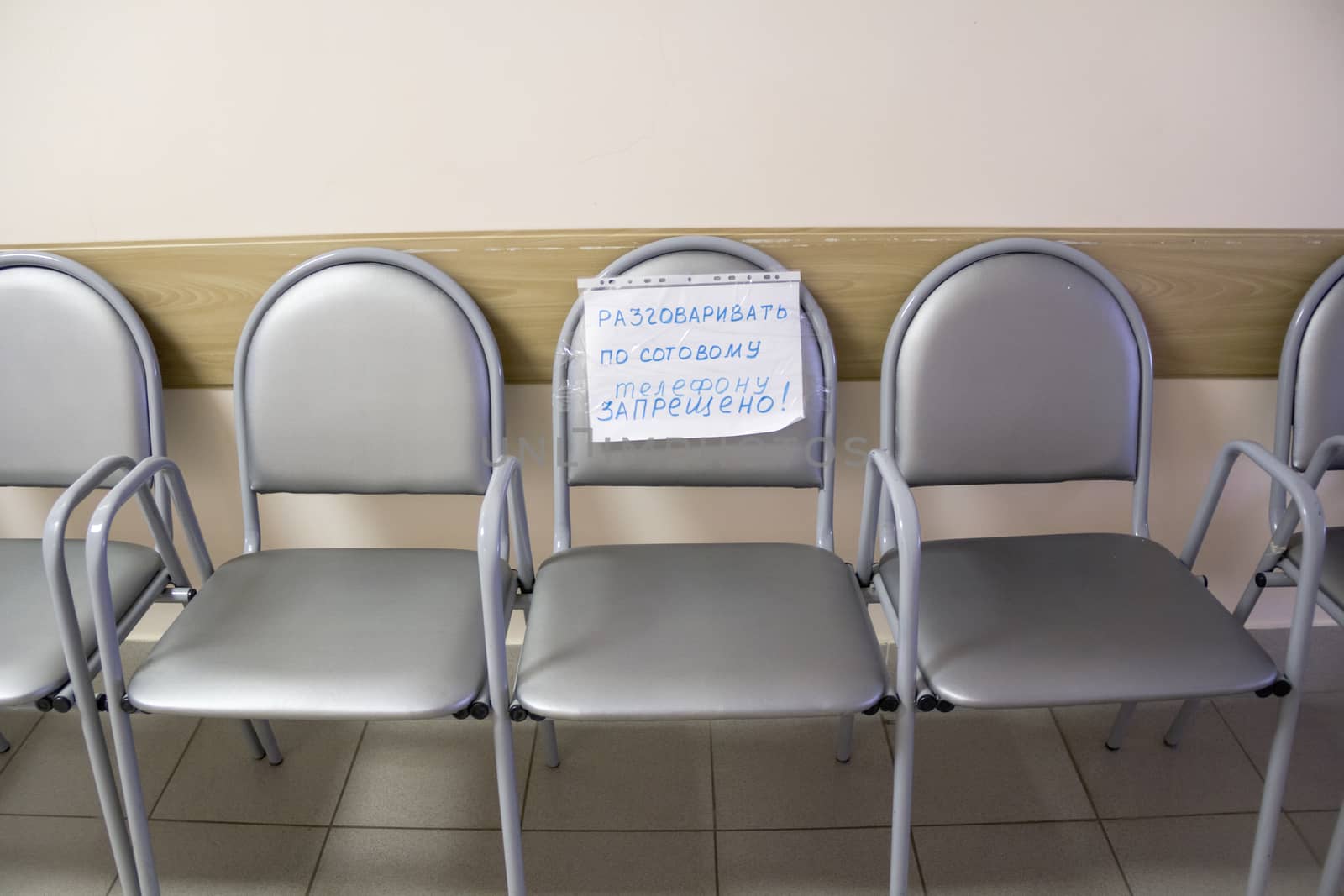 Row of chairs with an attached note in empty corridor