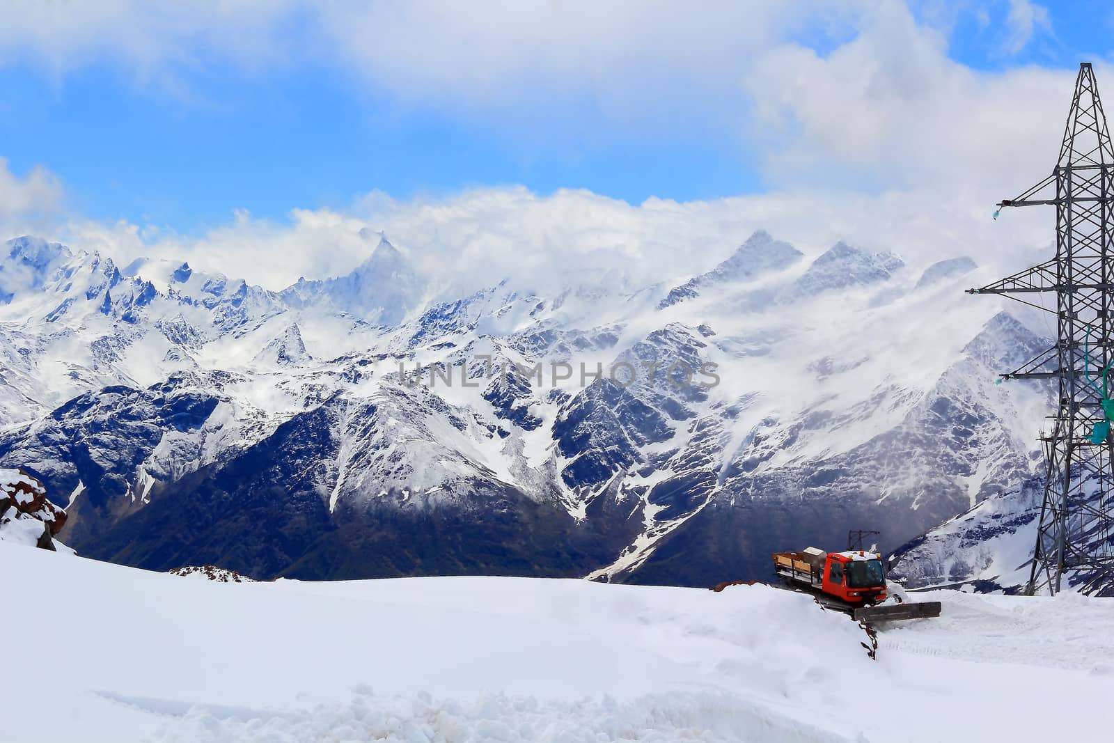 Winter landscape of Caucasus mountains with snowplow machine