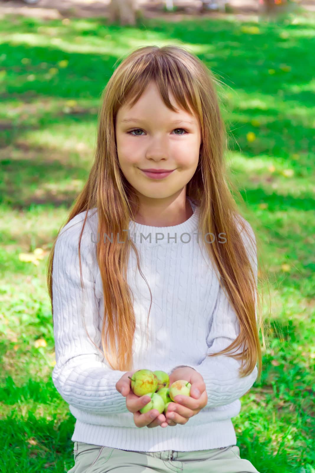 Photo of cute girl with apples in summer
