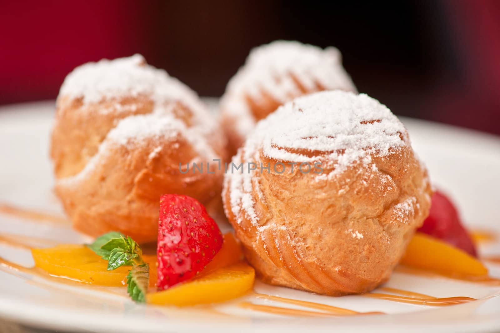 profiteroles from cream and condensed milk decorated with strawberry and peach