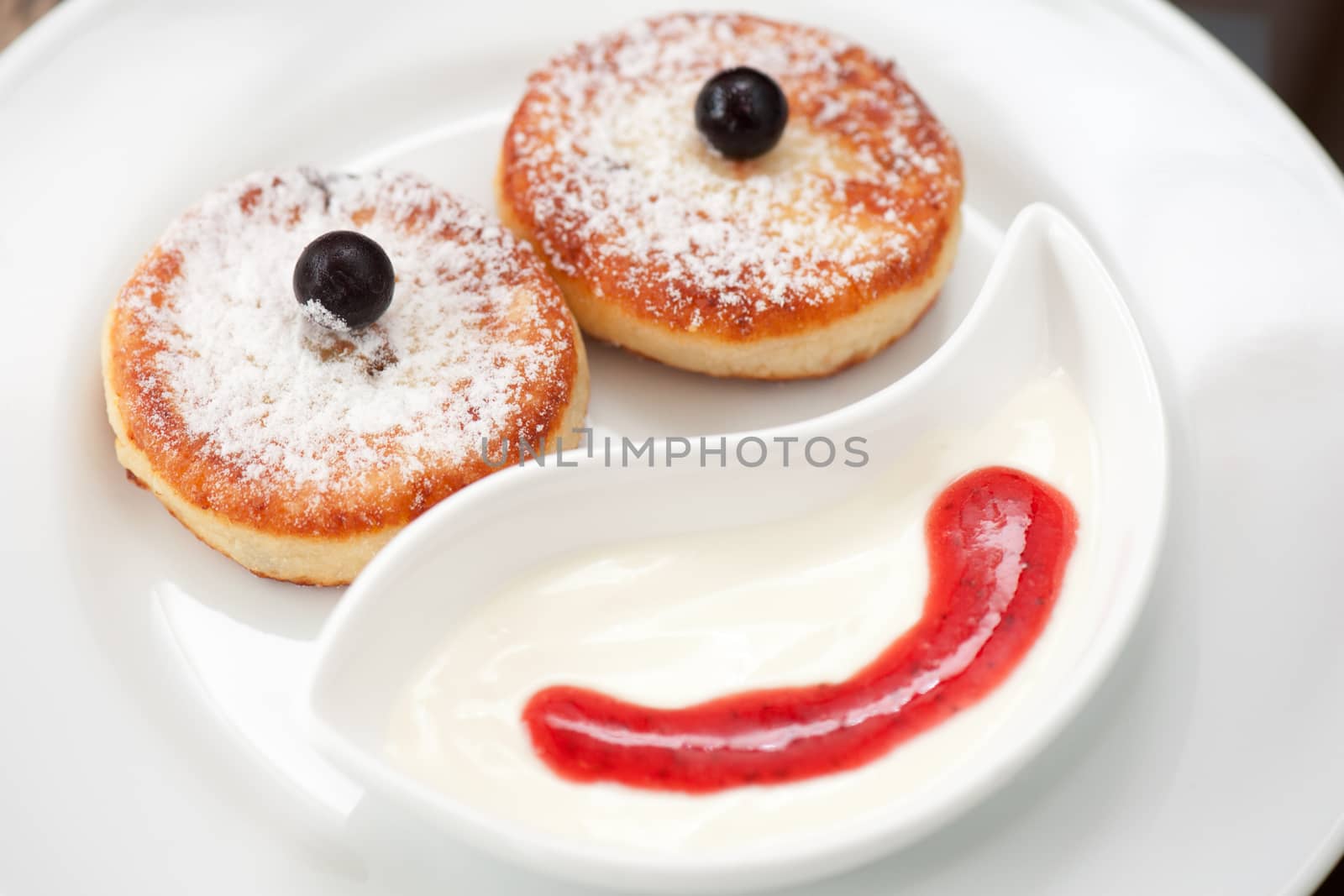 cottage cheese pancakes with strawberry sauce and sour cream