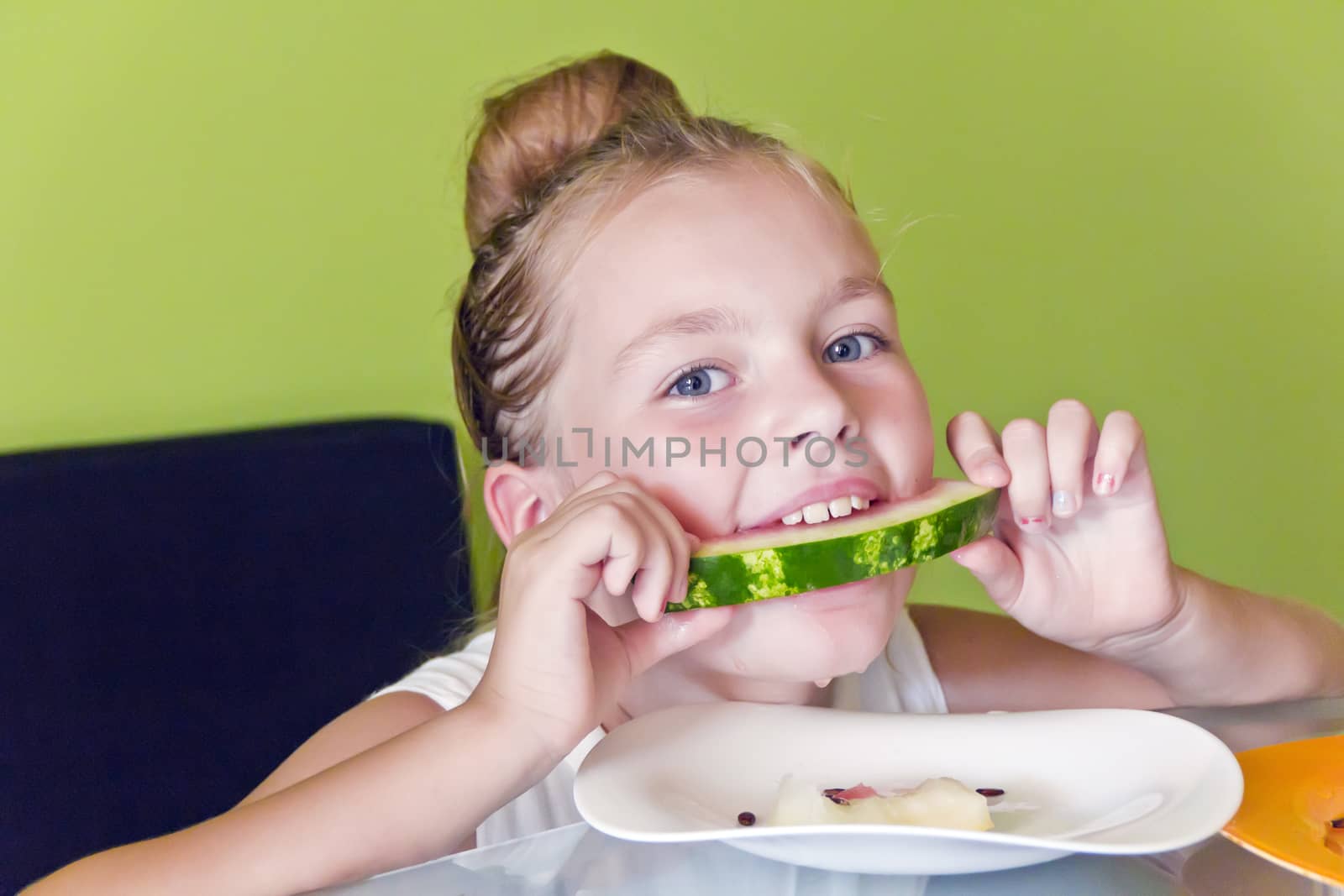 Photo of the cute girl eating watermelon