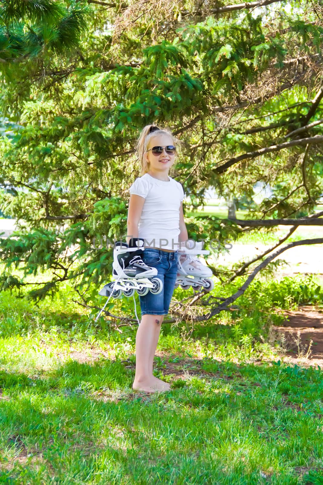 Photo of smiling girl playing with roll skates 
