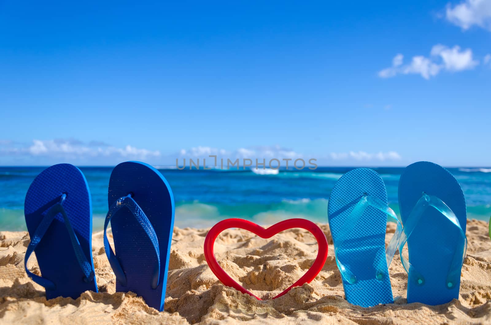Flip flops with heart shape on the sandy beach in Hawaii, Kauai (romantic concept)