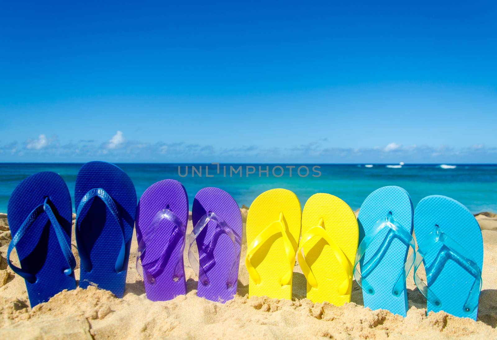 Colorful flip flops on the sandy beach by EllenSmile