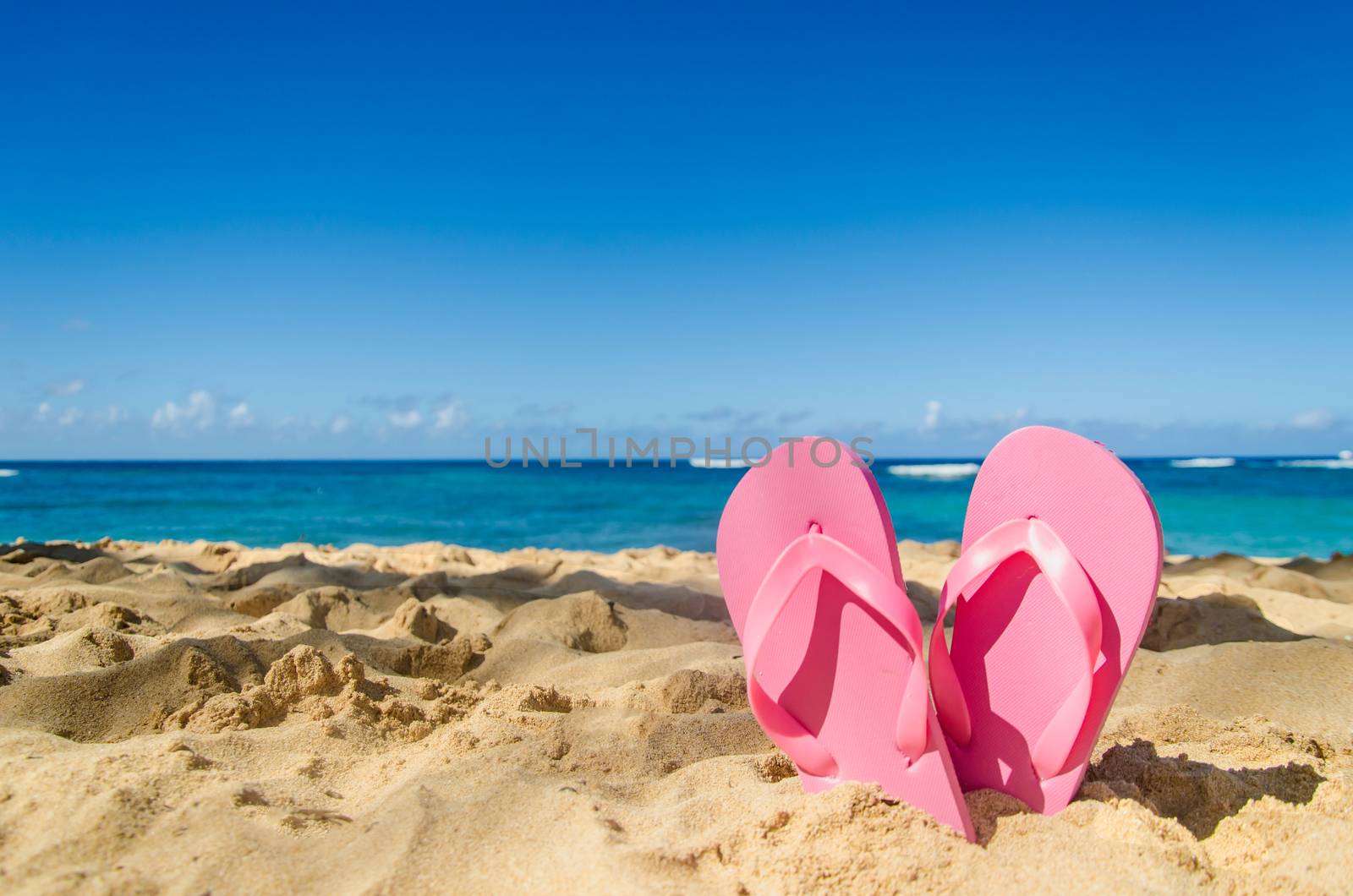 Pink flip flops on the sandy beach in Hawaii, Kauai