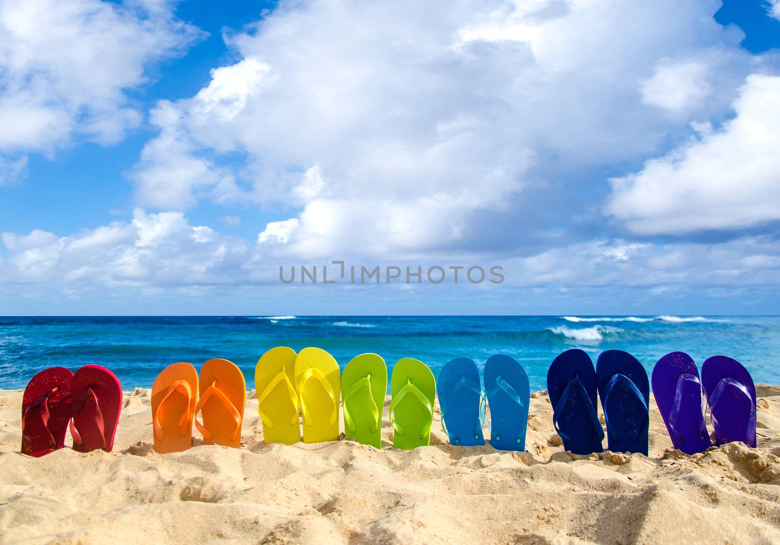 Colorful flip flops on the sandy beach by EllenSmile