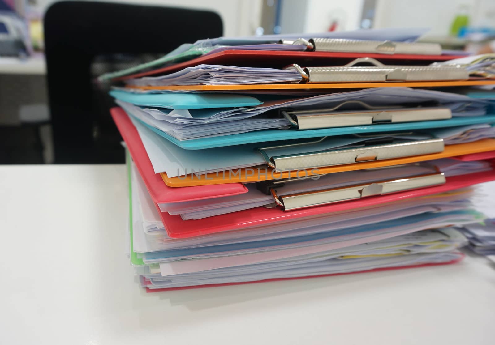 Stack of plastic clipboard and file document placed on desk at office.                              