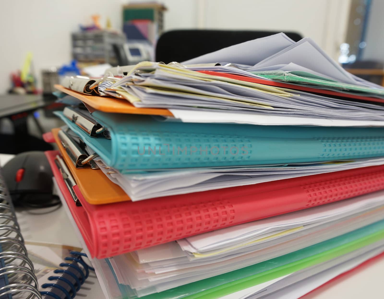 Stack of plastic clipboard and file document placed on desk at office.                               