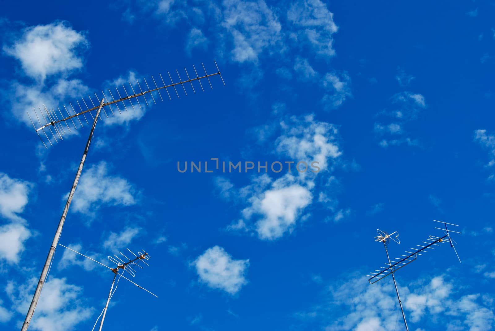 the three antenna are standing over blue sky
