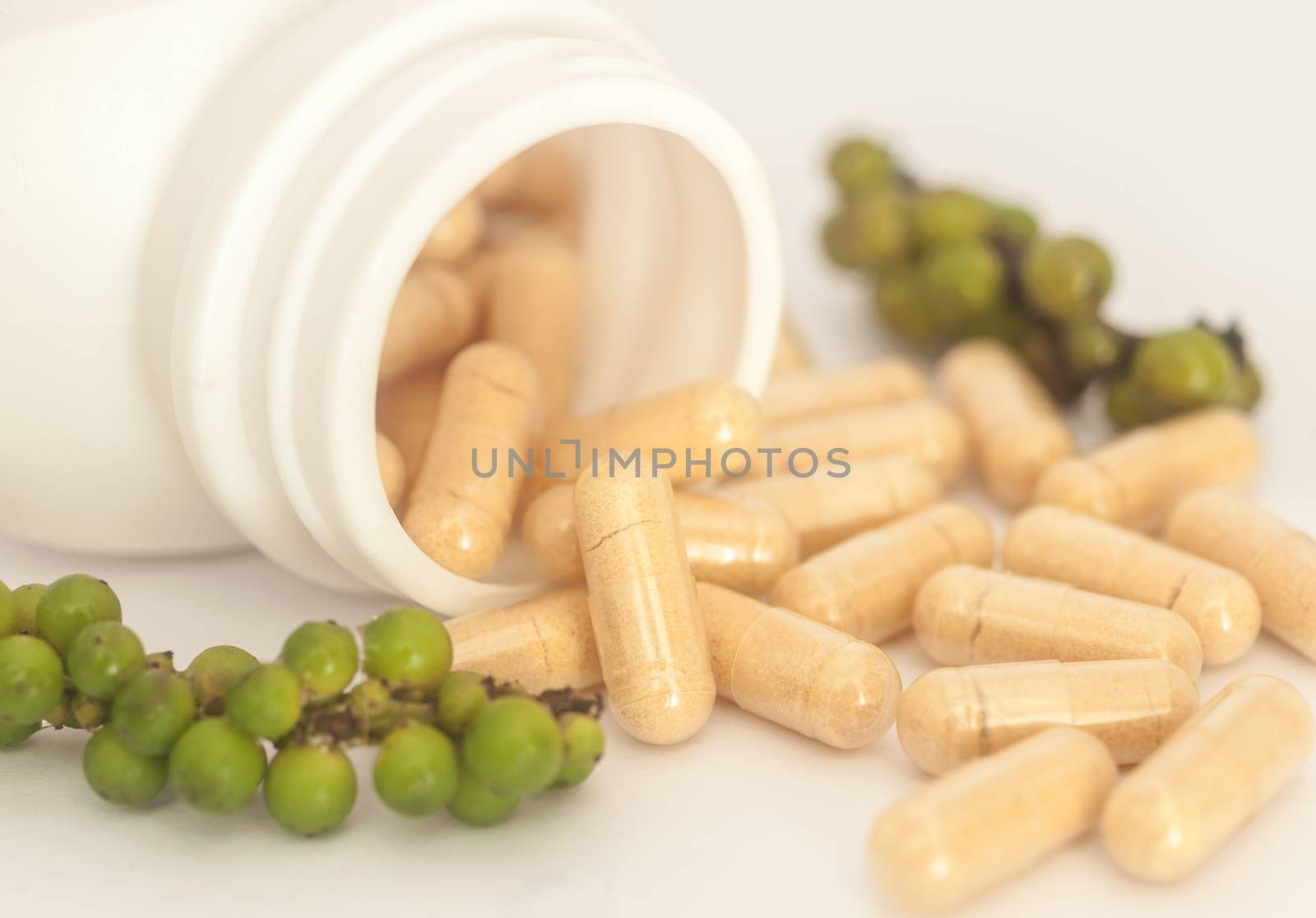 Herb in capsule spilling out of a bottle, Vitamin for health