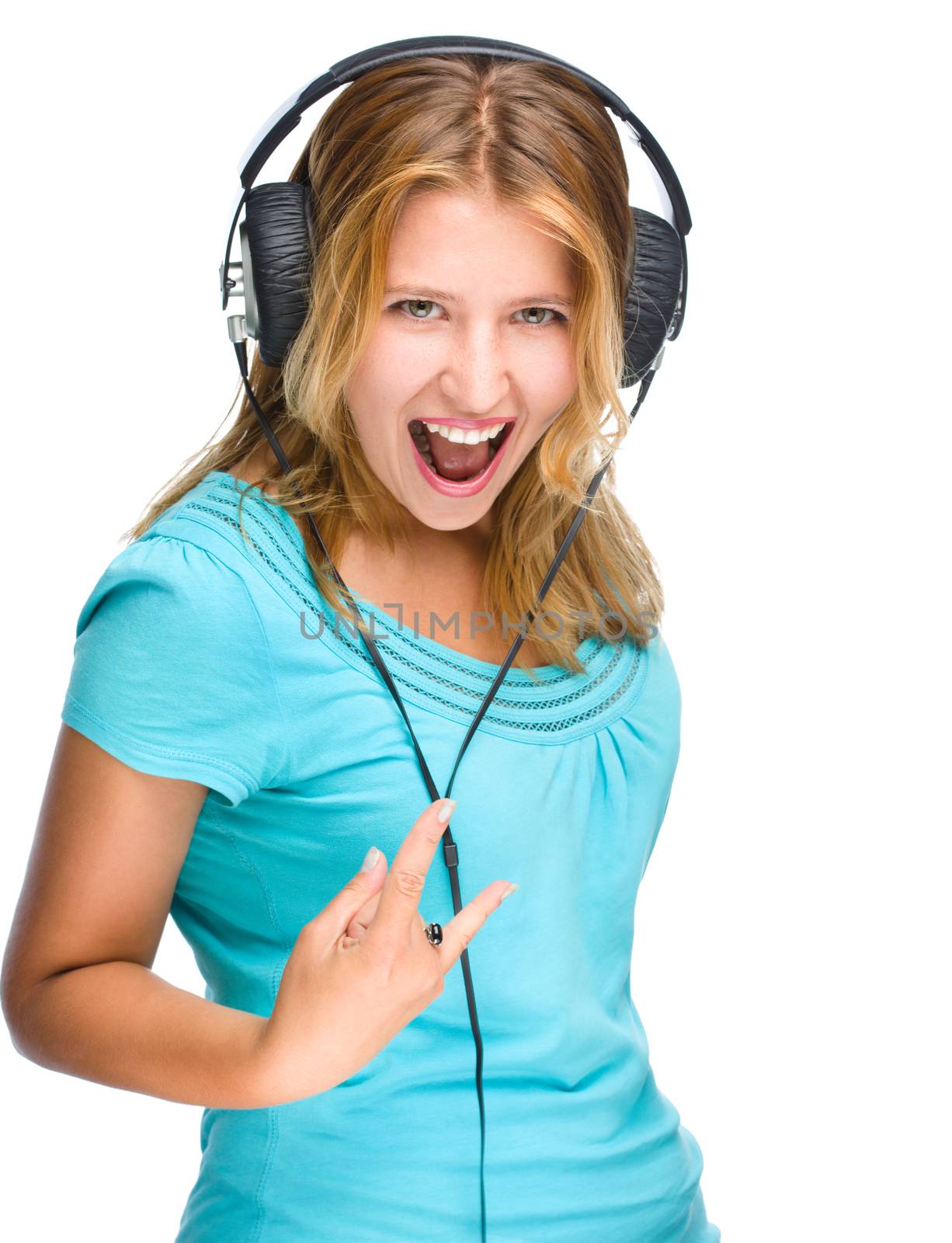 Beautiful girl with headphones show rock symbol isolated on a white background