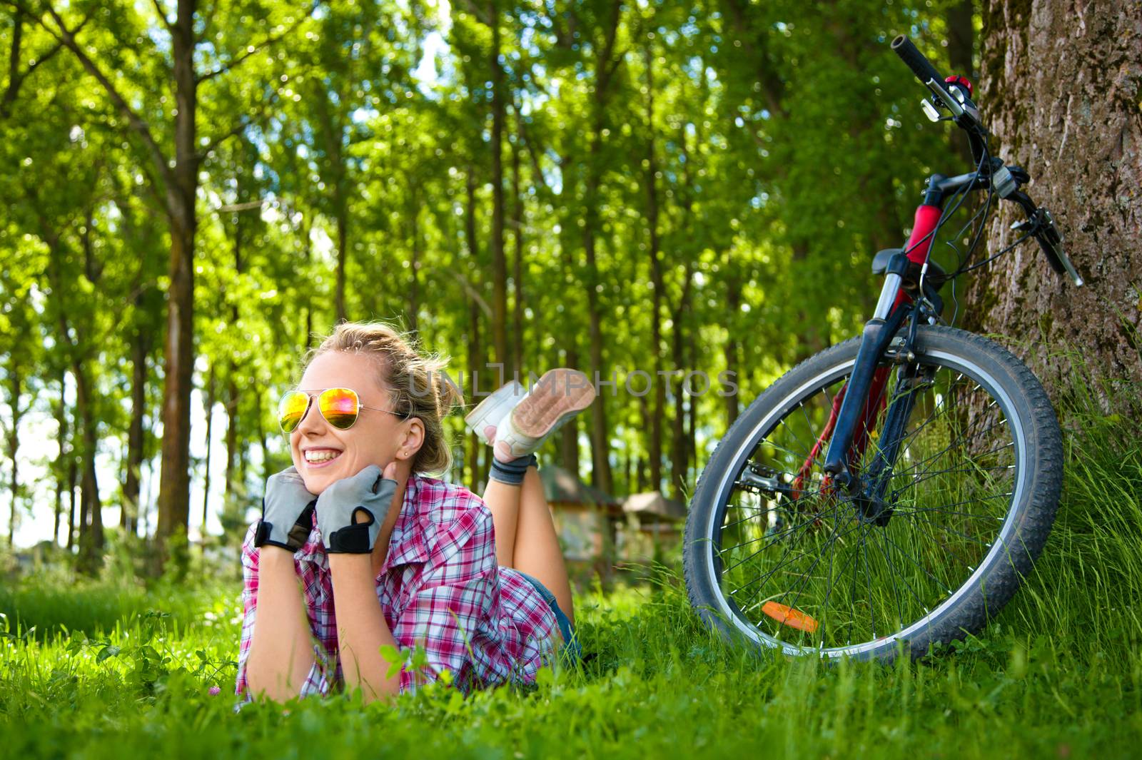 Young cyclist relaxation lying in the fresh green grass