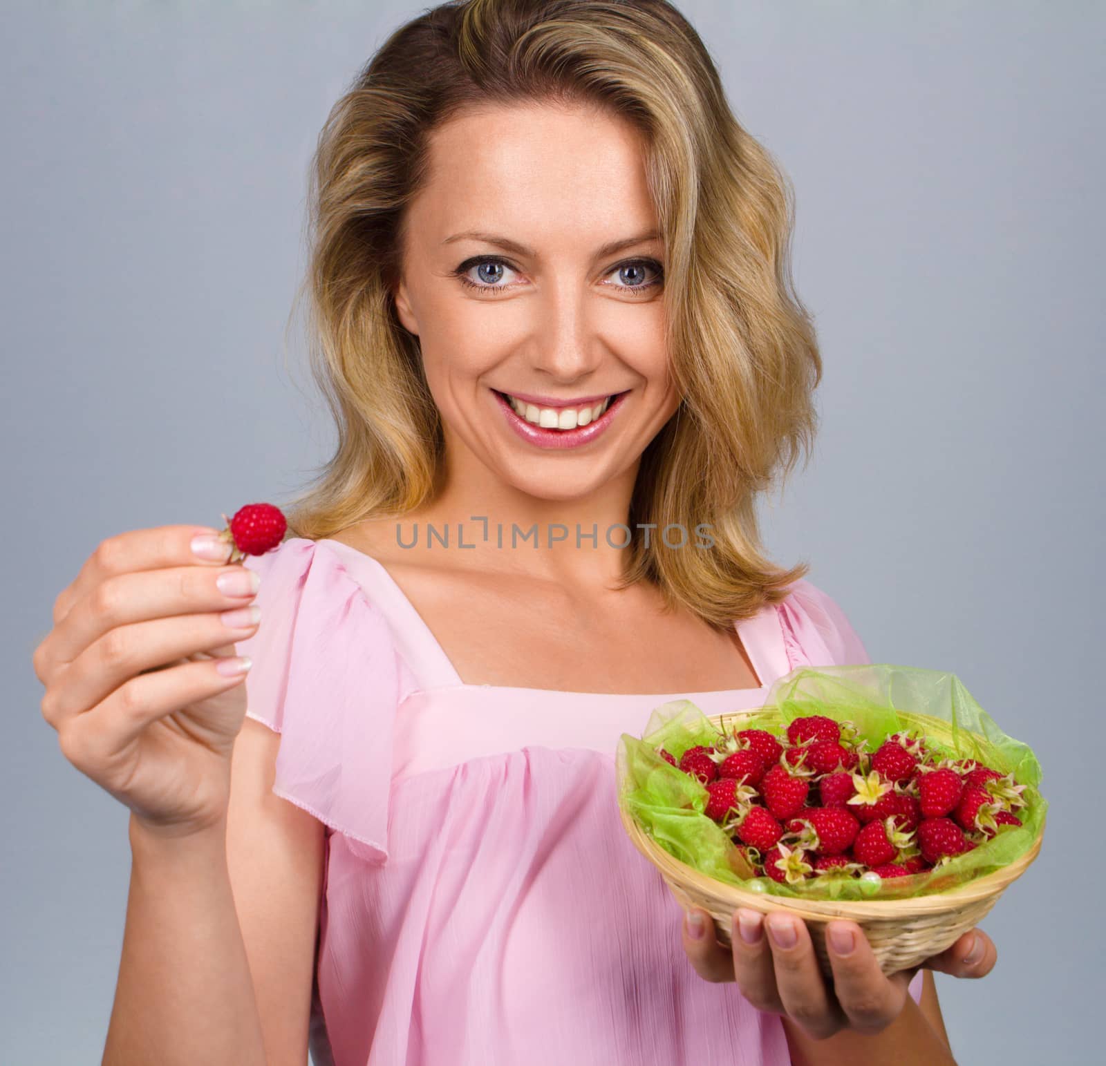 Close up of smiling woman holding raspberries