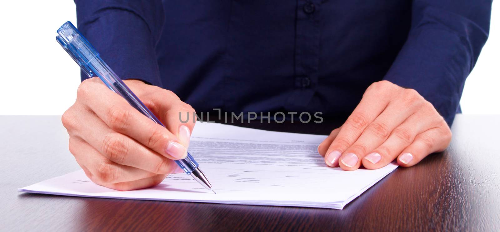 Woman in blue shirt signs a contract on a table, isolated over white