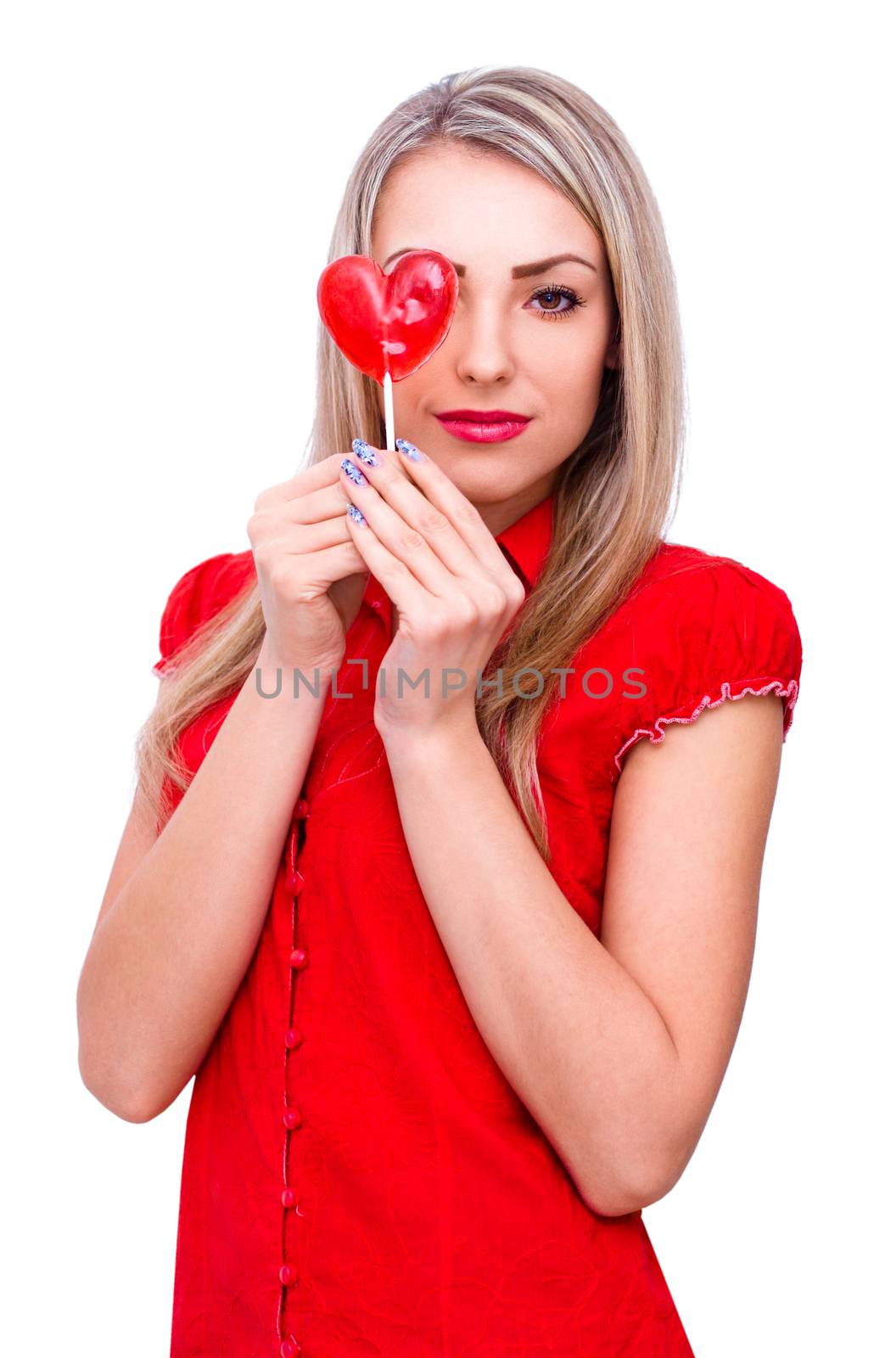 Beautiful young woman holding heart shape lollipop in front of her eye, isolated on white
