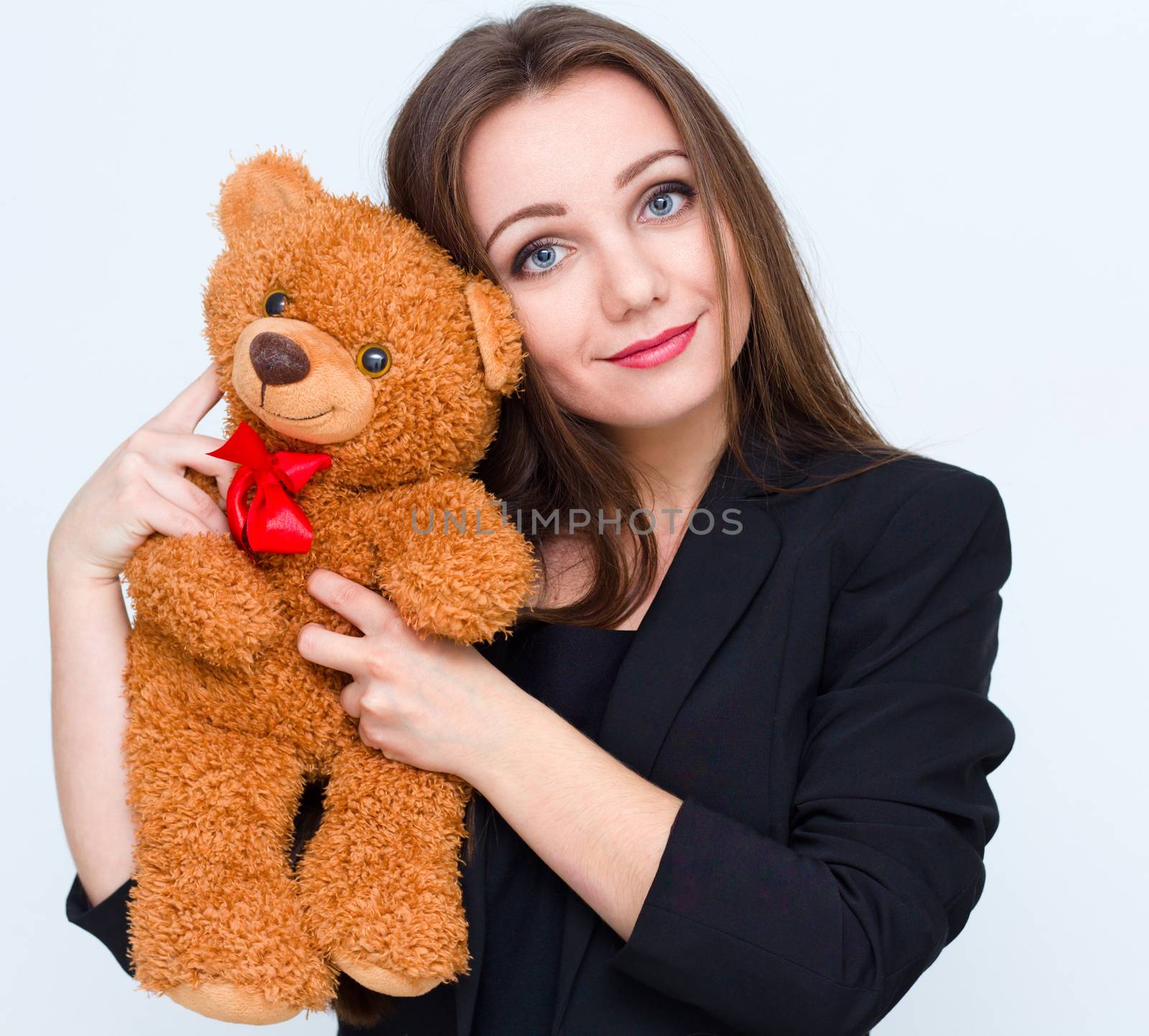 Young smiling beautiful woman holding brown teddy bear
