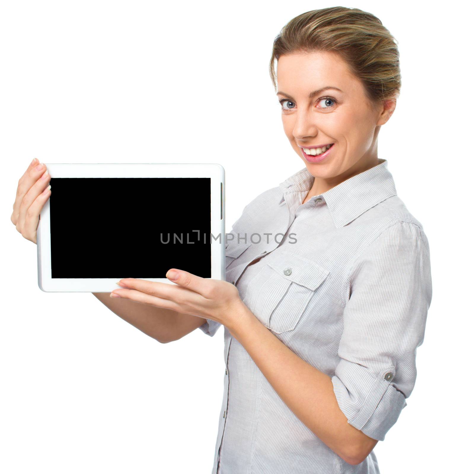 Young cheerful woman is showing blank tablet, isolated over white