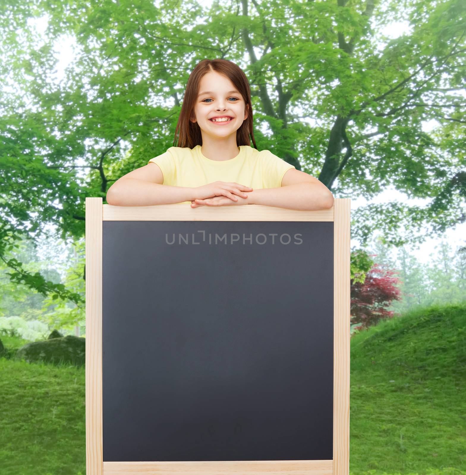 happy little girl with blank blackboard by dolgachov