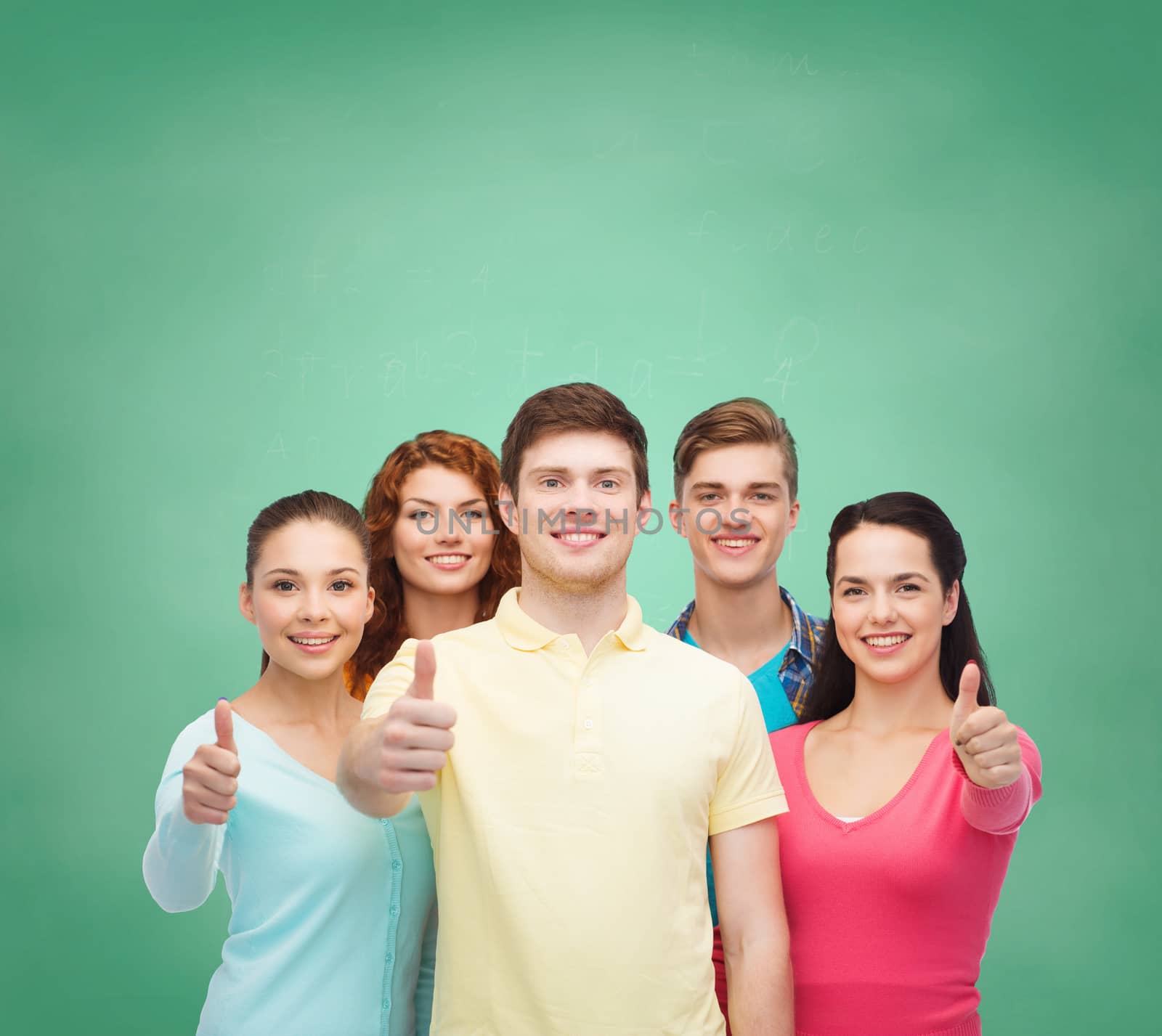 group of smiling teenagers over green board by dolgachov