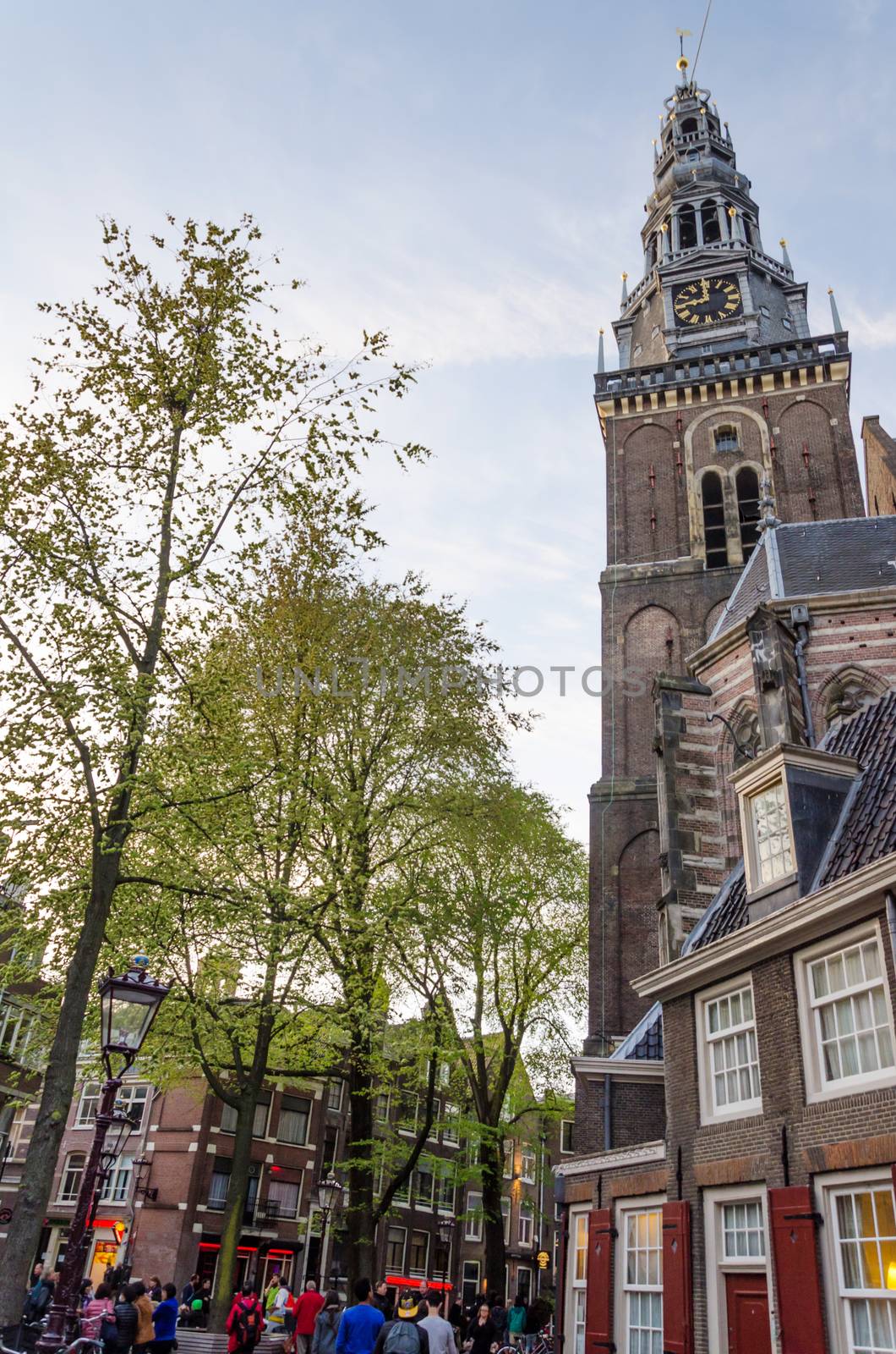 Amsterdam, Netherlands - May 8, 2015: Tourists around Old Church in Amsterdam, Netherlands. by siraanamwong