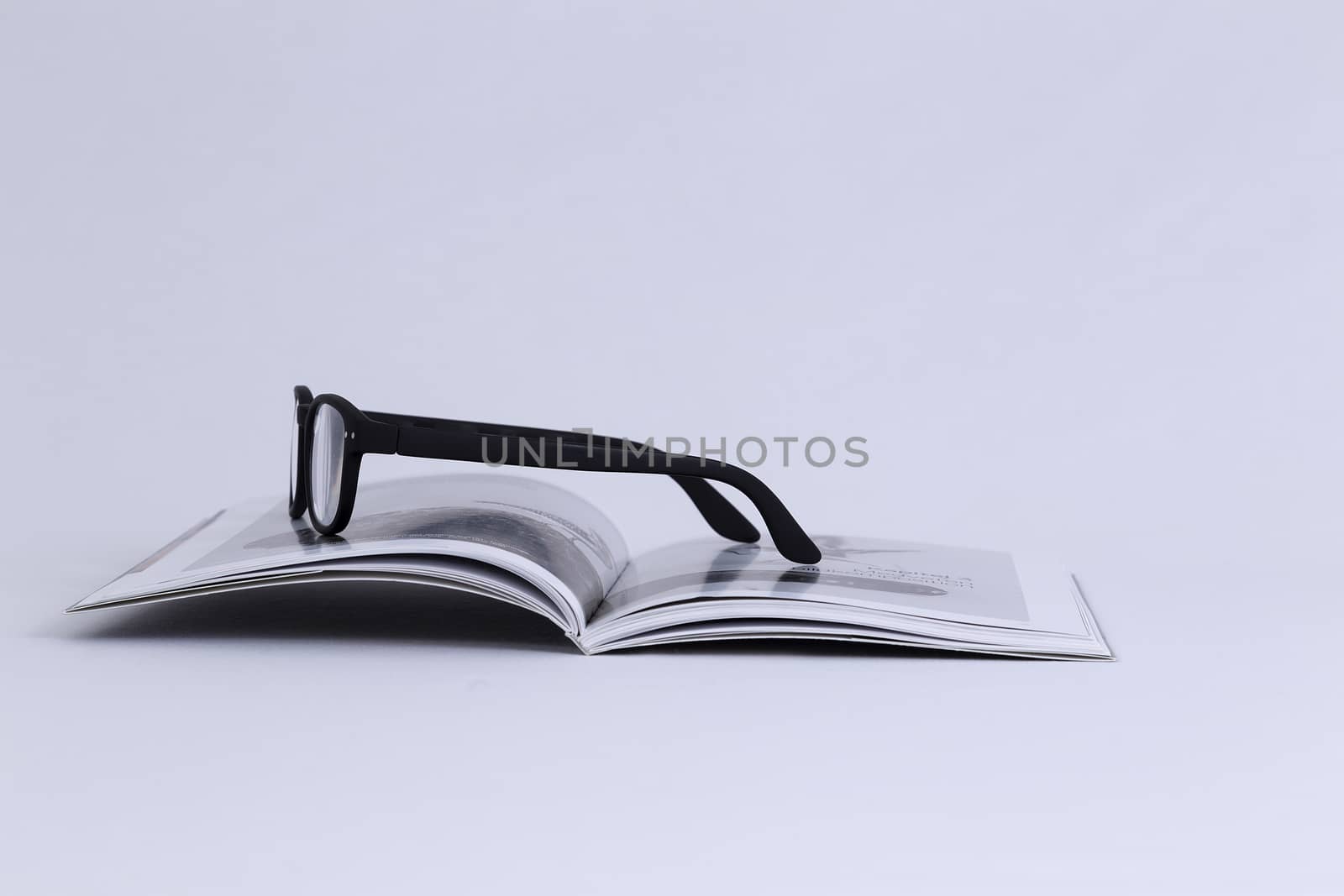 A pair of glasses on an open book  (isolated)
