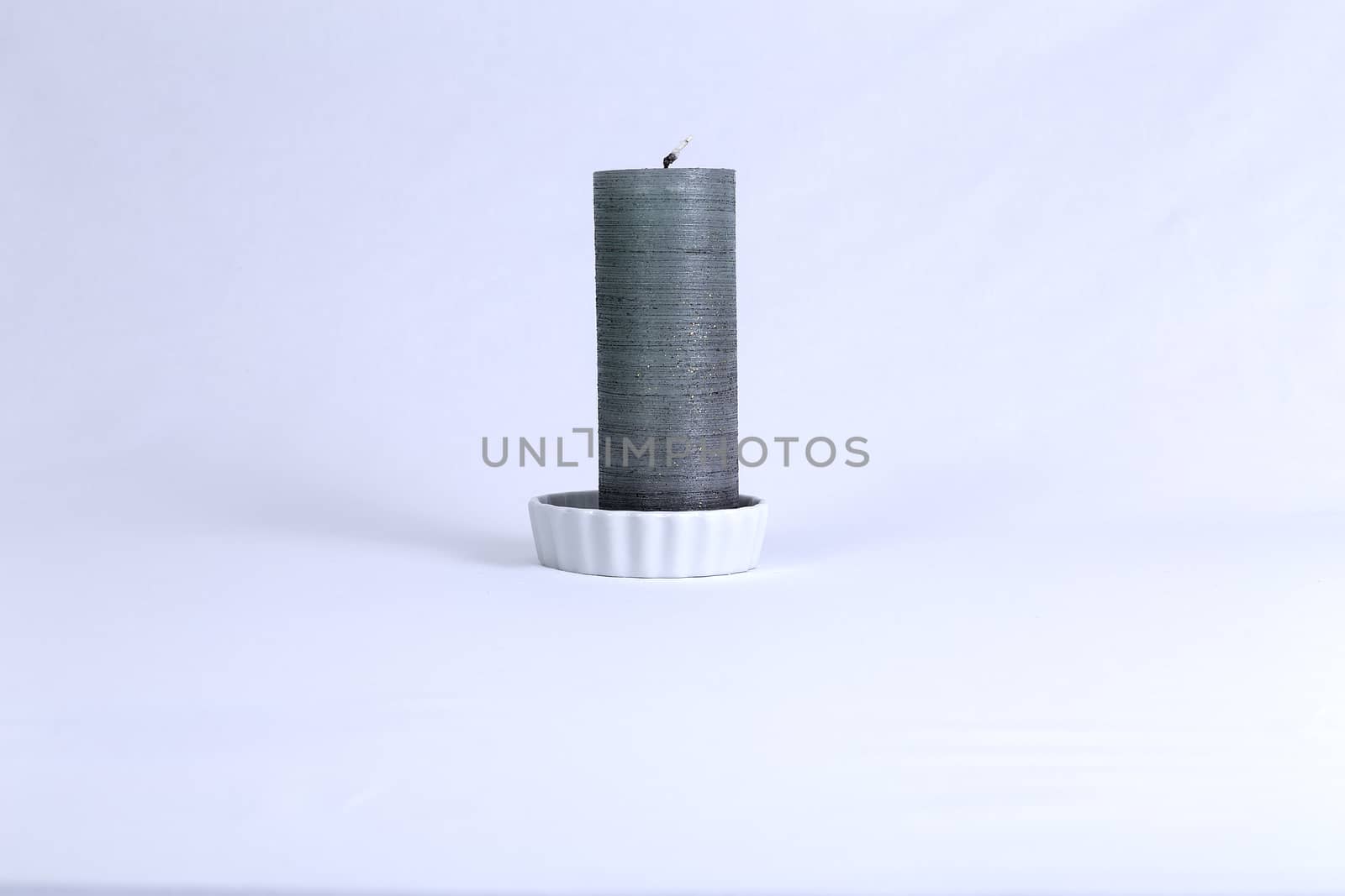 An isolated silver candle on a plate