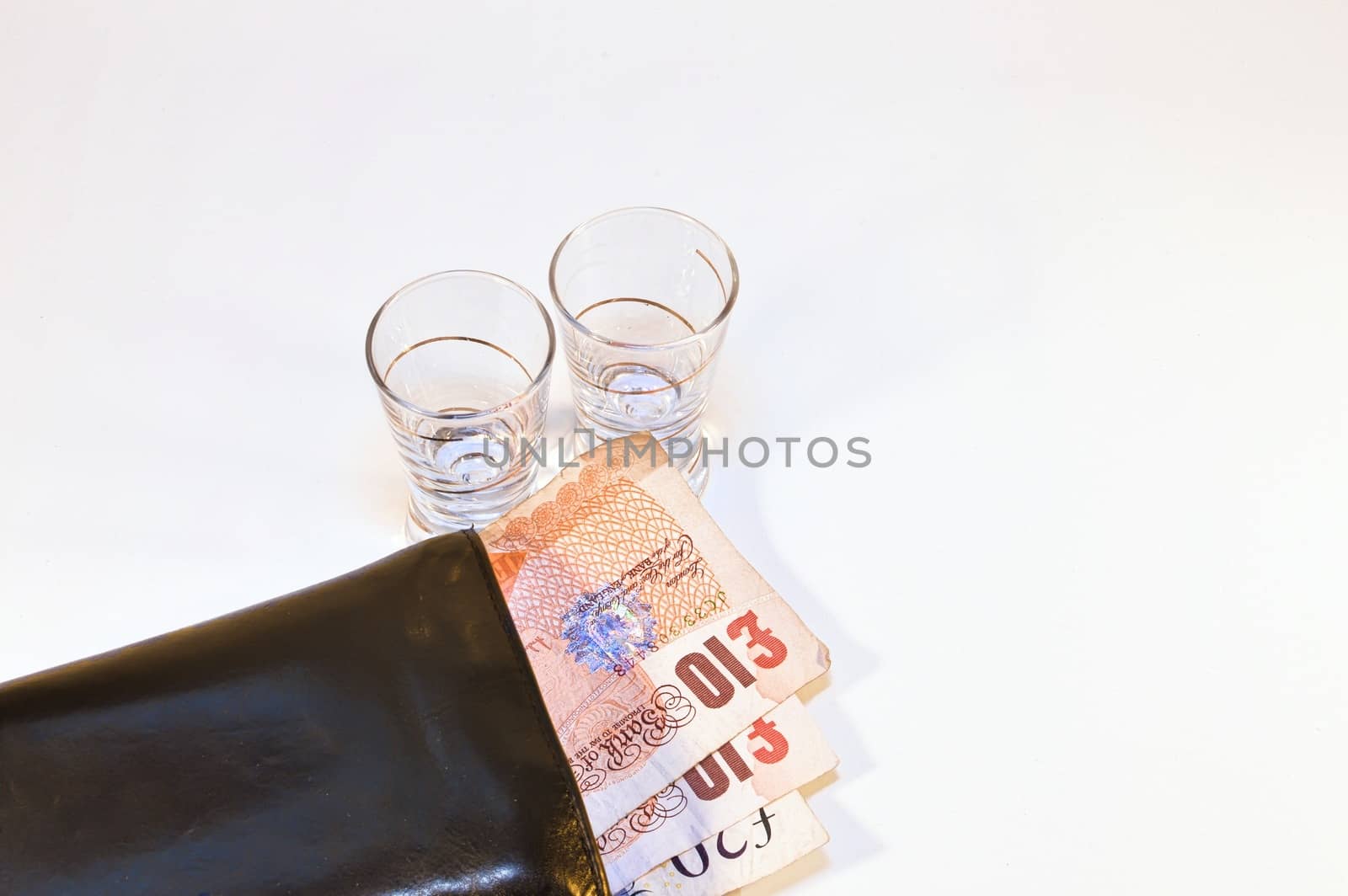 two vodka glasses on banknotes ten pounds